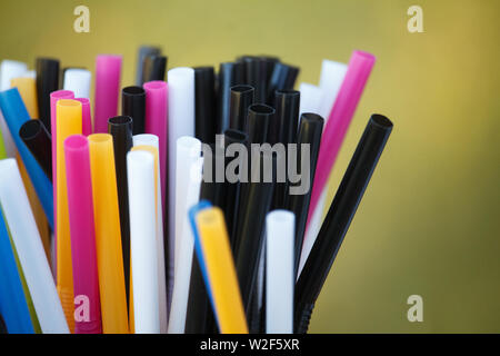 Closeup of multicolored plastic cocktail tubes on blurred background Stock Photo