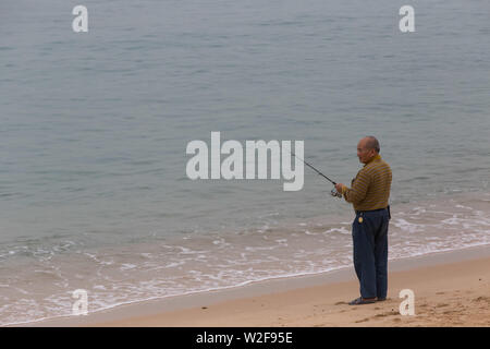 Old man fishing by the sea, Tung Wan Stock Photo