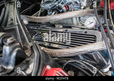 A view of the Edelbrock valve cover and the surroundings in the engine compartment. Refurbished American car. Stock Photo