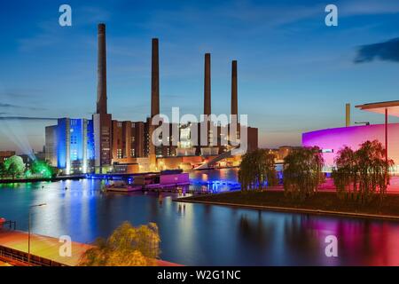 VW plant with VW combined heat and power plant, colored illuminated at dusk, Autostadt Wolfsburg, Wolfsburg, Lower Saxony, Germany Stock Photo