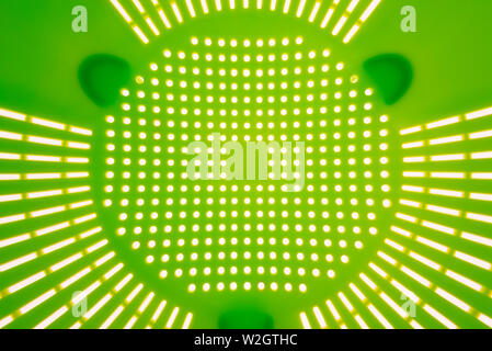 Close-up of a green plastic colander, a kitchen utensil to drain pasta, on a white background Stock Photo