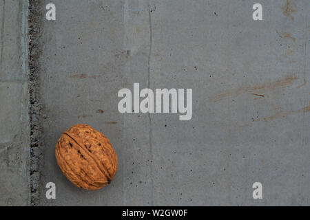 Walnut shell on grey concrete texture representing healthy food Stock Photo