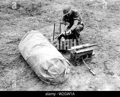 Fifth Army. Anzio Area, Italy. Dummy tank designed by British, made of rubber and inflated when used. Can be assembled in 20 minutes. When used in field can simulate tank positions. Dummy rubber tank used by British, in carrying Bag. Body and turret are separate pieces but are contained in this bag together. In the right background can be seen an Italian generator which is used to inflate the body assembly, and in the right foreground is seen the standard British Army Engineer Issue Gorge Pump which is used to inflate the turret. Stock Photo