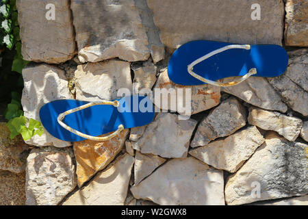 Sandals glued to a wall of stone. Stock Photo
