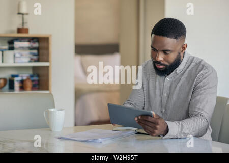 African American man doing his online banking with a tablet Stock Photo