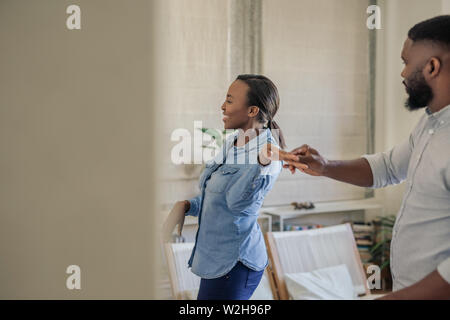 Laughing young African American couple dancing together at home Stock Photo
