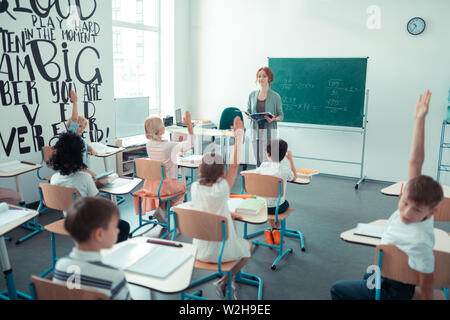 Maths teacher reading a mathematical problem in the classroom. Stock Photo