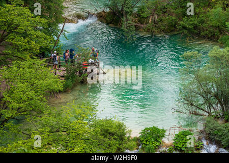 Tourists at a wooden observation platform at the Plitvice Lakes National Park in Croatia Stock Photo