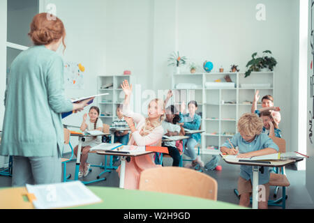 School children doing sums with their maths teacher. Stock Photo