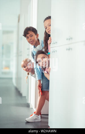 Children showing their tongues while having fun during break at school Stock Photo