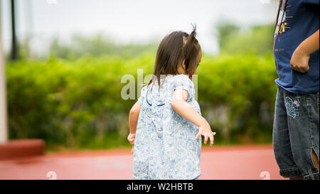 Asian girl playing with older sister in the park. Stock Photo