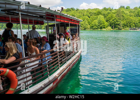 Ferry navigating on the azure colored crystal clear and pure water of Lake Kozjak, Plitvice Lakes National Park, Croatia Stock Photo