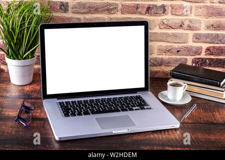 Notepad, pen, books, laptop and cup of coffee on dark wooden office ...