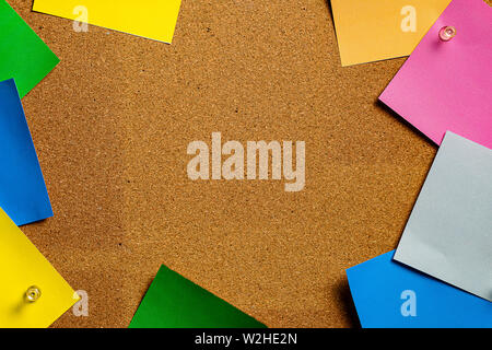 Corkboard/Bulletin Board with a group of various colored sticky notes bordering a central open cork area perfect for Copywriting. Stock Photo