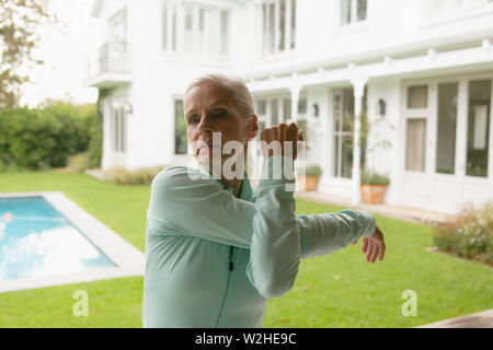 Active senior woman exercising in porch at home Stock Photo