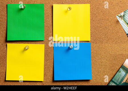 Corkboard/Bulletin Board and blank Sticky Notes in Yellow, Green and Blue, arranged in a very orderly fashion.  Great for Copywriting. Stock Photo
