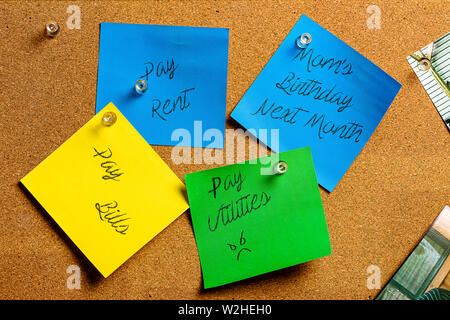 Corkboard and Sticky Notes in Yellow, Green and Blue. Pre-Written with various common payment and birthday reminders. Stock Photo