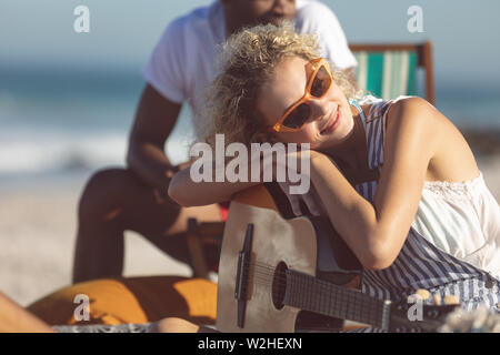 Woman with guitar relaxing on the beach Stock Photo