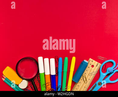 Colorful  school suplies on red  background with copy space. Back to school concept, top view. Stock Photo