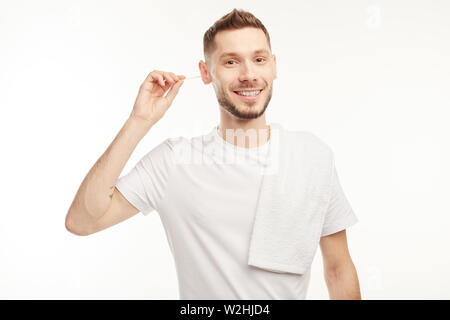 Young man on the white background uses cotton swabs. Stock Photo