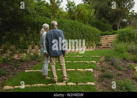 Active senior couple standing together hand in hand at garden Stock Photo