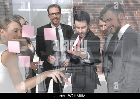 group of business people reading business notes on a glass Board Stock Photo