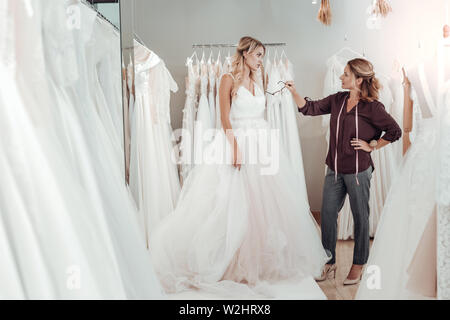 Tailor giving young woman advice about her dress. Stock Photo