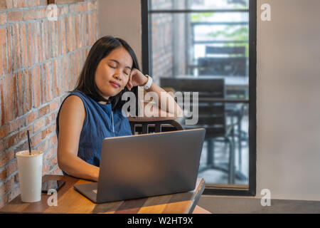 Restless woman closing her eyes while working on computer Stock Photo