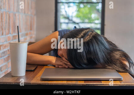 Close up of Asian woman freelancer falling asleep on laptop  Stock Photo