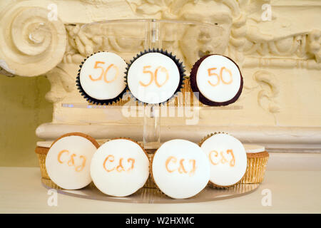 Layers of mini iced cakes on display at a couple's 50th wedding anniversary party Stock Photo