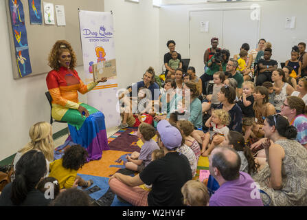 Drag Queen Story Hour, a national organization runs programs intended to instill a love of reading in young kids and also seeks to spread messages about self-love, acceptance of others and appreciation of diversity: Parents & children listen to a story at the Crown Heights Stock Photo
