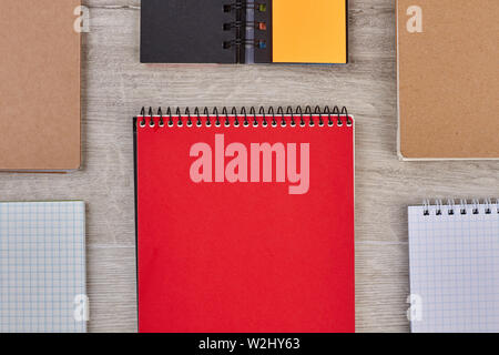 Group of paper notebooks on wooden background. Stock Photo