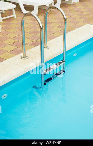 Metal handrails in the pool.The descent into the water. Vacation, rest and relaxation Stock Photo