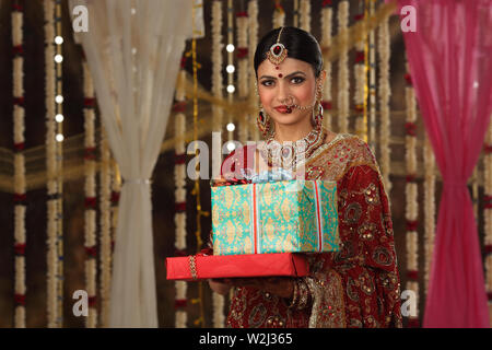 Portrait of an Indian bride holding gift boxes Stock Photo
