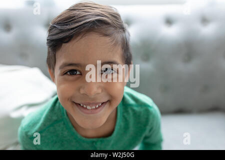 Boy smiling on a sofa in living room at home Stock Photo