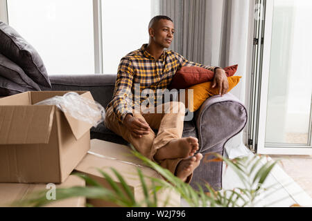 Man relaxing on a sofa in living room at home Stock Photo