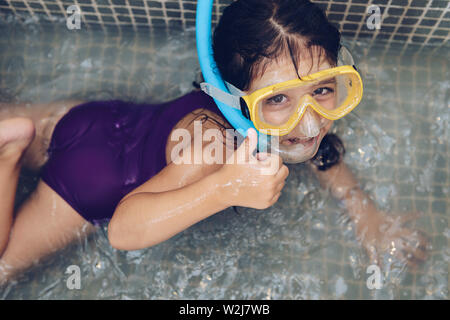 Little girl swimming in the bathroom with closed eyes Stock Photo