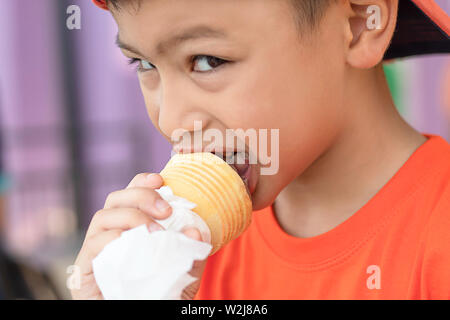 The boy holding the ice cream eating Stock Photo