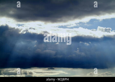 SUNSCREEN: Clouds in a distant Virginia sky filter the sunrays through a dramatic cloudscape down to the earth. Stock Photo