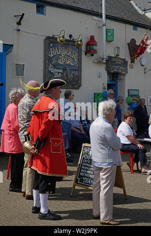 Watchet town crier in England, dressed in traditional red coat and black tricorn hat standing with his bell in his hands Stock Photo