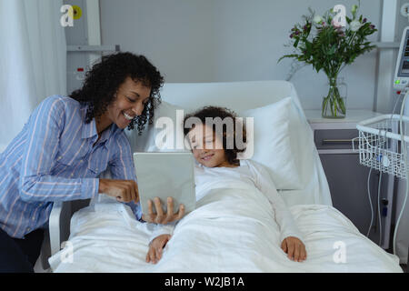 Mother and son using digital tablet in the ward at hospital Stock Photo
