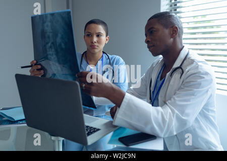 Male and female doctors looking at x-ray report in hospital Stock Photo