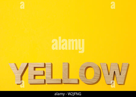 Word Yellow laid out in wooden letters on color background Stock Photo