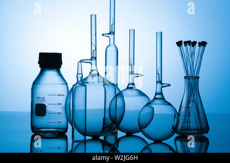 Glass laboratory measurement flasks in chemistry environment in blue