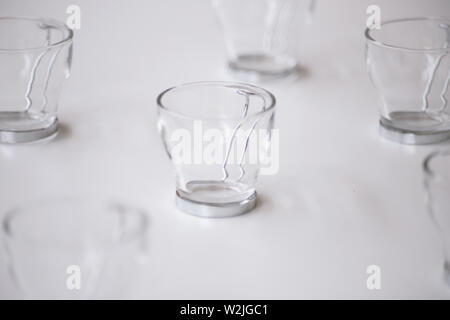 Close Up Cappuccino Glass Coffee Mug with metal handle on white table. copy space Stock Photo