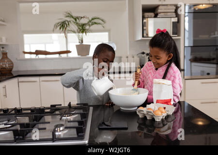 Siblings preparing food on a dining table in kitchen at home Stock Photo