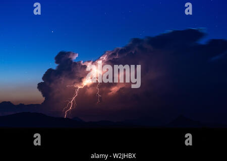 Lightning strike from a thunderstorm cumulonimbus cloud over the Organ Mountains near Las Cruces, New Mexico Stock Photo