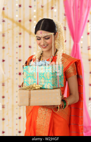 Indian young bride holding gift boxes Stock Photo