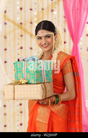 Portrait of an Indian bride holding gift boxes Stock Photo