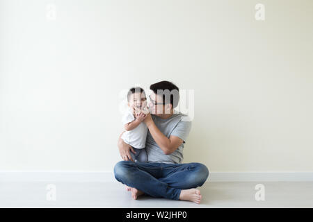 Asian father and son playing and smiling on floor in the room, Family having fun and laughs concept Stock Photo